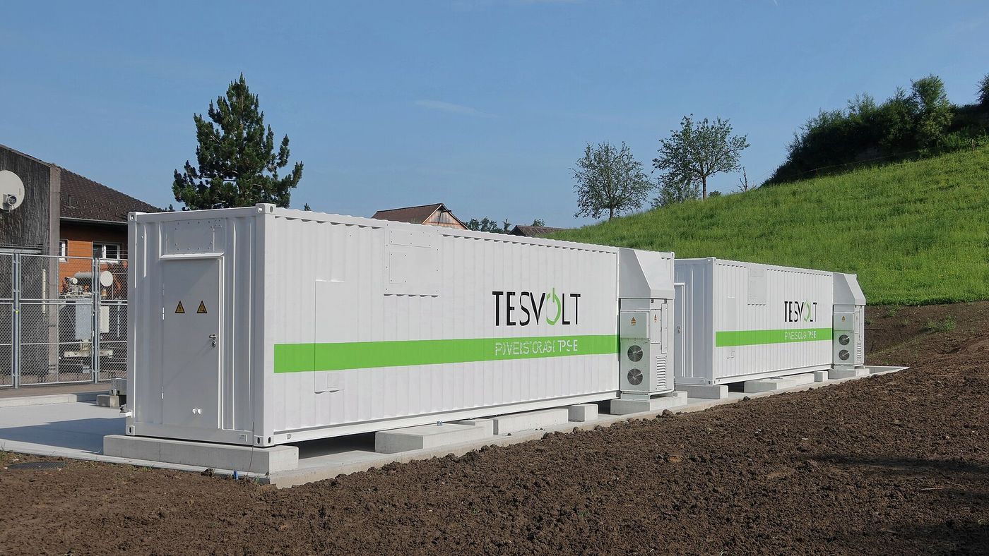Containerised battery storage units beside an electricity substation.