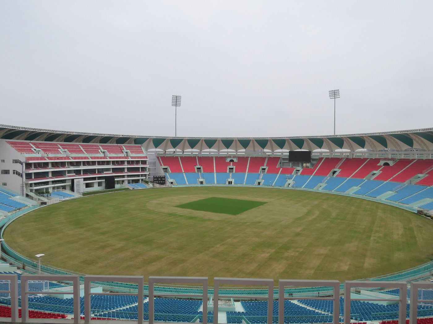 A floodlit cricket ground in India during a day-night international.